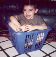 Isaiah playing in a laundry basket